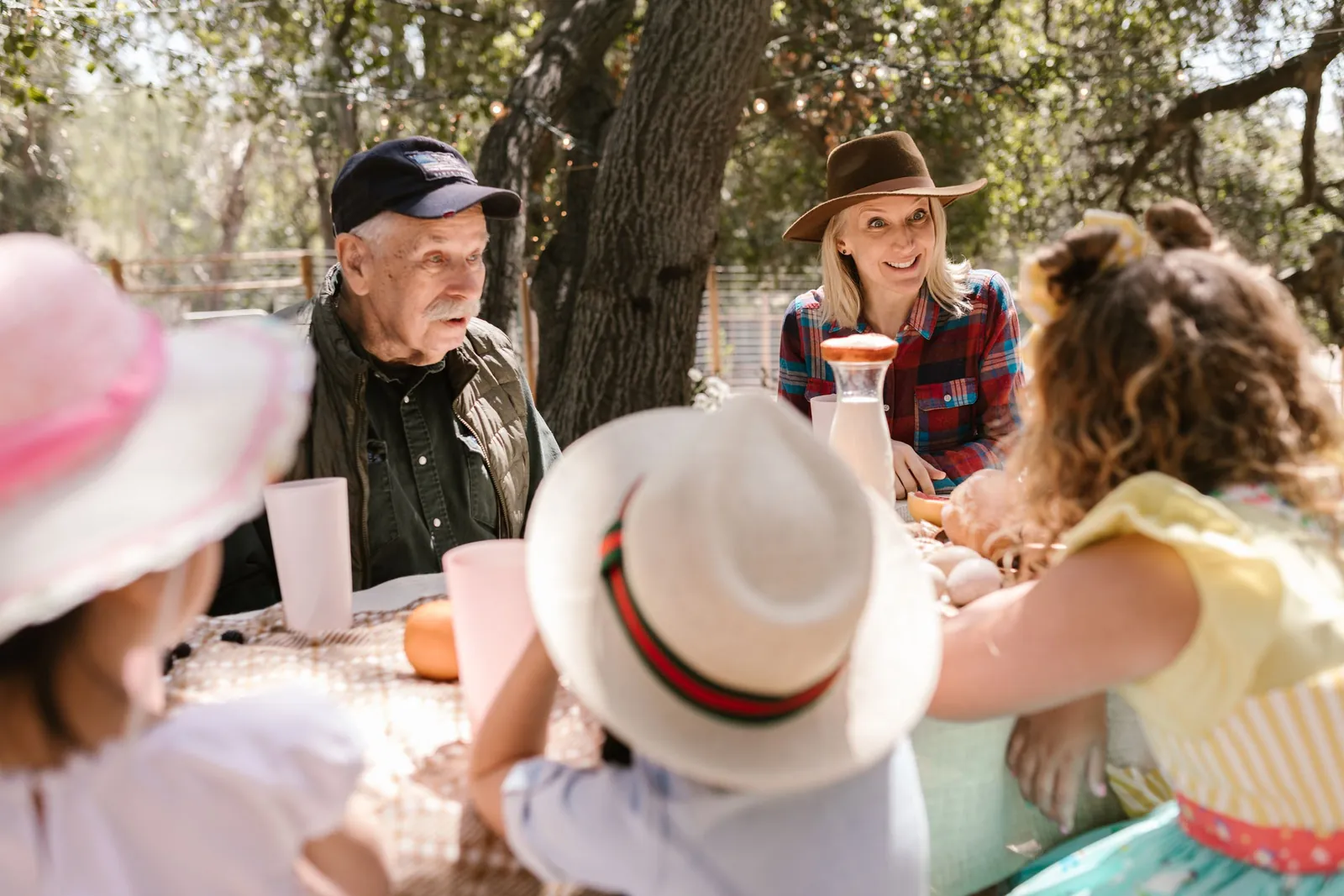 Grands-parents, parents et enfants réunis autour d'une table dans le jardin