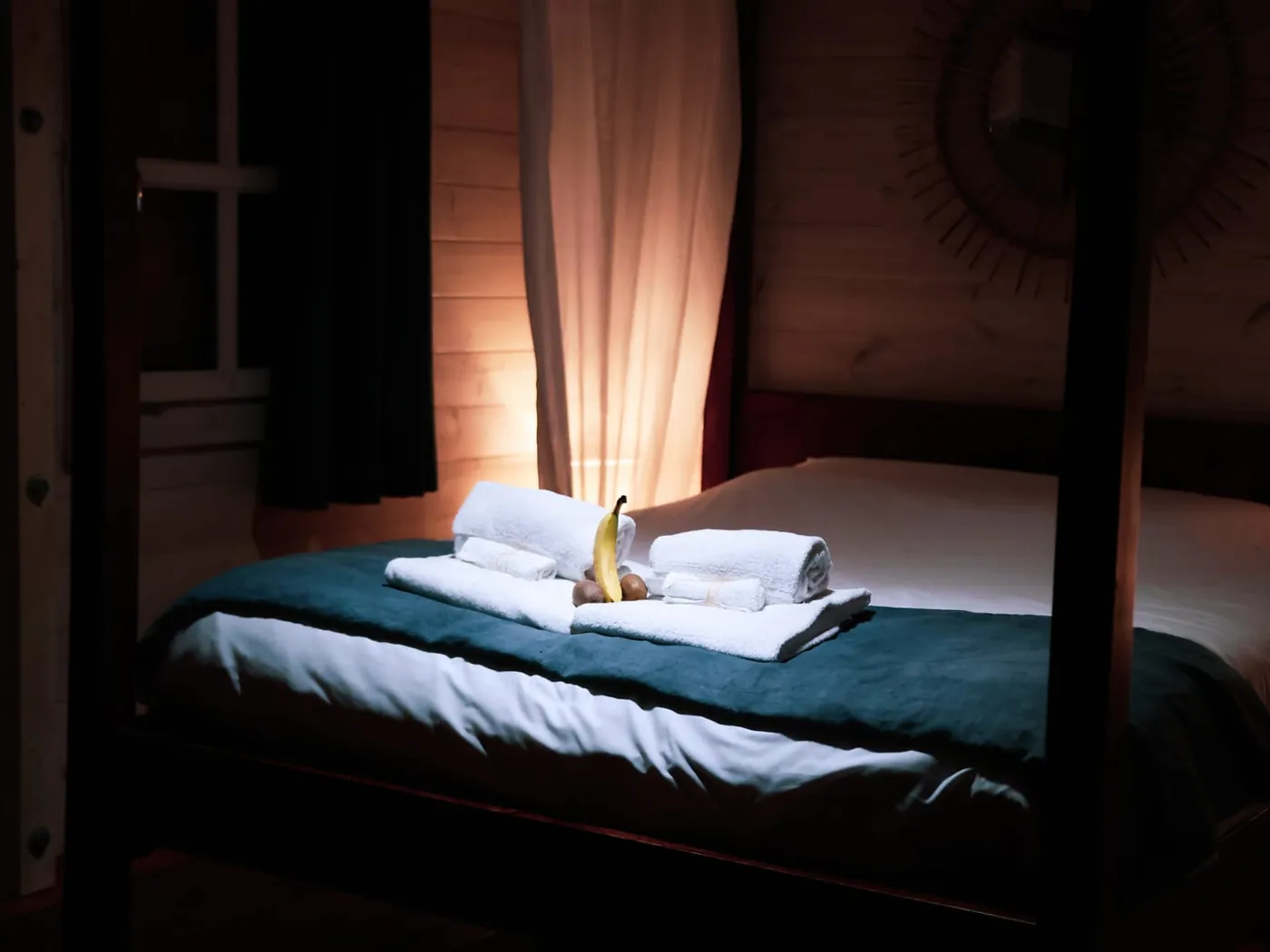 The Love Room at Domaine du Dahu, ready for guests — four-poster bed, towels and a basket of fruit, soft lighting