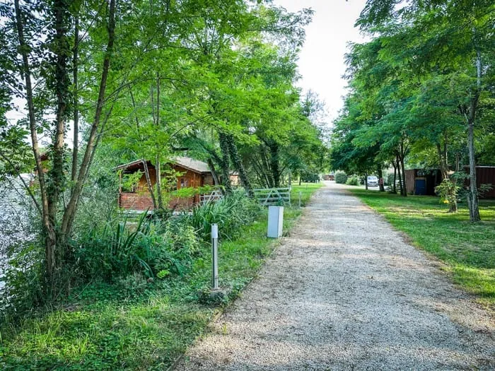 Allée arborée qui longe le lac et dessert les chalets – privatisation du Domaine du Dahu